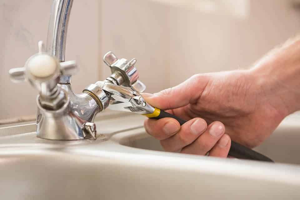 Plumber repairing a broken faucet